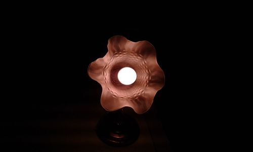 Close-up of illuminated lamp against black background