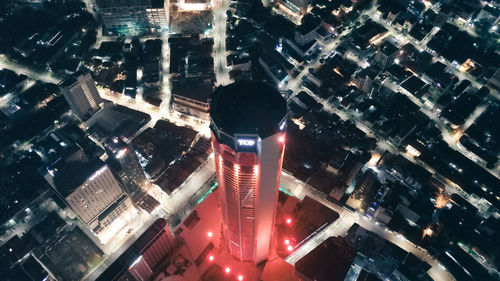 High angle view of illuminated street amidst buildings at night
