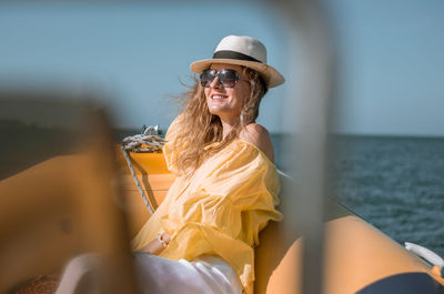 Woman sitting by sea