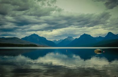 Scenic view of lake by mountains against sky