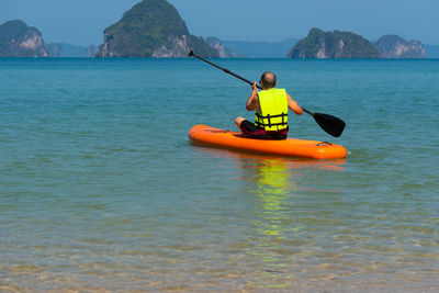 Man rowing boat in sea