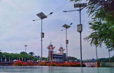 Street lights by building against sky