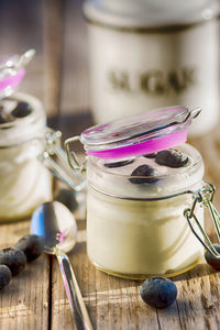 Close-up of blueberries with yogurt in jars on table