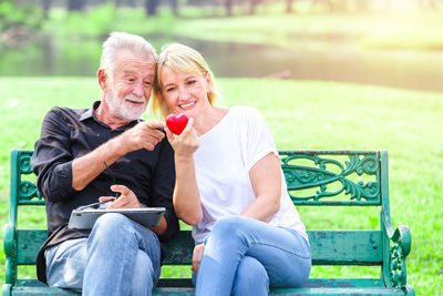 Friends sitting on seat in park