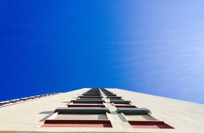 Low angle view of buildings against clear blue sky