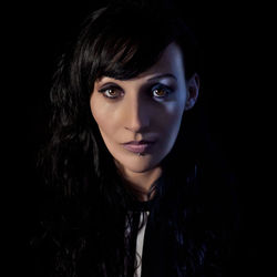 Close-up portrait of a beautiful young woman over black background