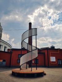 Low angle view of house by building against sky