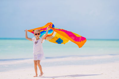 Woman standing on beach against sky