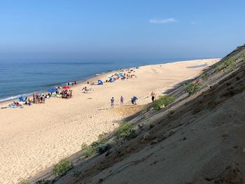 People at beach against blue sky