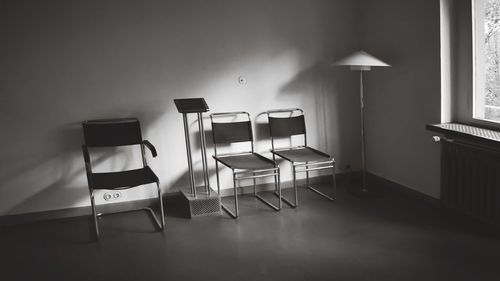 Empty chairs and table against wall at home