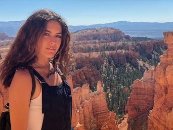 Portrait of teenage girl standing against rocky mountains at bryce canyon 