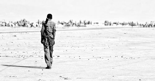 Rear view of woman walking on beach