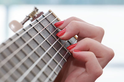 Cropped hand of woman playing guitar