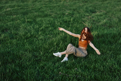 High angle view of girl playing with ball on grassy field