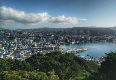High angle view of town by sea against sky
