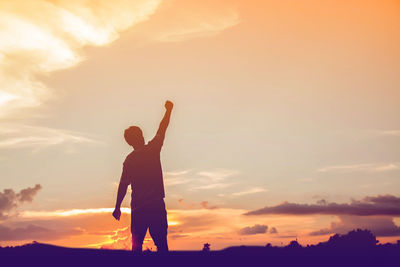 Silhouette man standing against sky during sunset