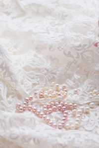 Close-up of pearl jewelry on lace fabric