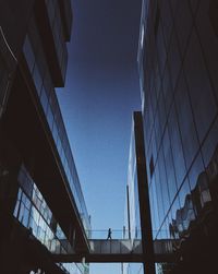 Low angle view of skyscrapers against blue sky