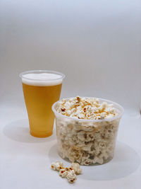 Close-up of popcorn and beer in disposable packages 