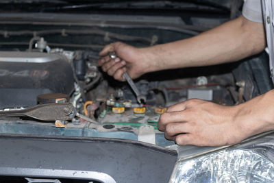 The mechanic is checking the engine.