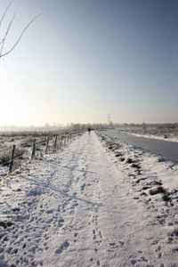 Snow on field against clear sky during winter