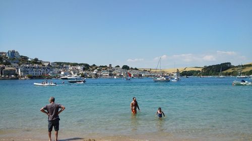 People on beach against clear sky