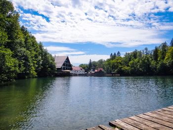 Scenic view of lake by buildings against sky