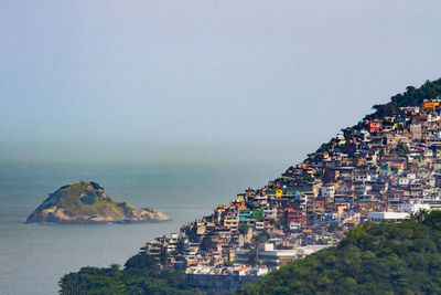 High angle view of townscape by sea against sky