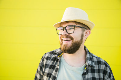 Happy man in front of yellow wall