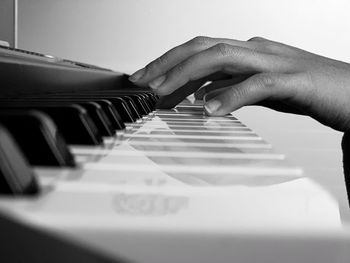 Cropped hand playing piano at home