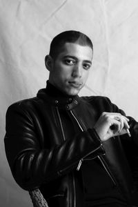 Portrait of young man standing against wall