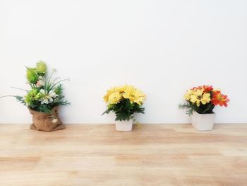 Flower vase on table against wall