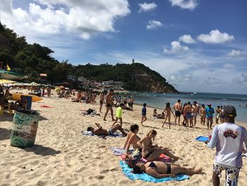 People at beach against sky