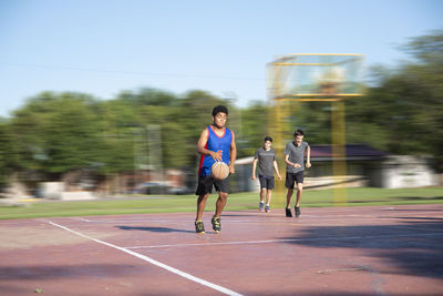 Teenagers playing street baskeball