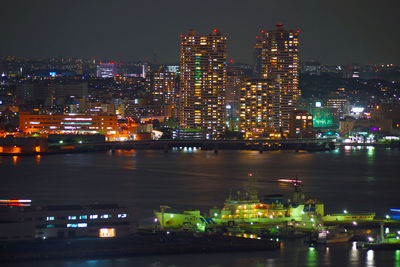 Illuminated buildings in city against sky at night