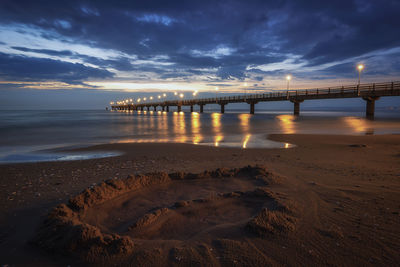 Bridge over sea against sky during sunset