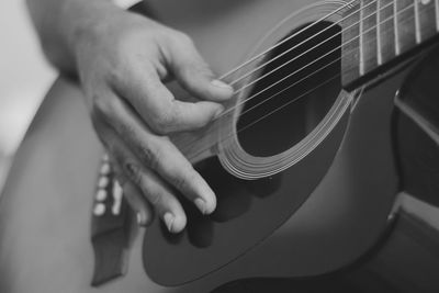 Midsection of man playing guitar