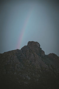 Low angle view of rocky mountain against sky