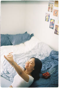 Young woman lying on bed at home