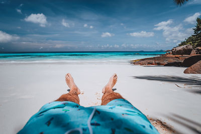 Low section of person relaxing on beach