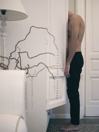 Rear view of man standing at home