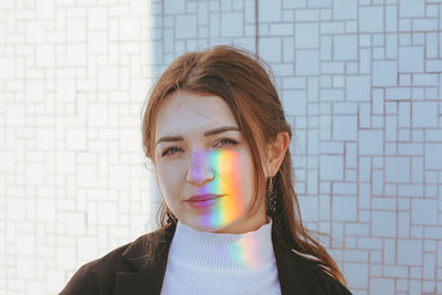 Close-up portrait of beautiful young woman standing against wall