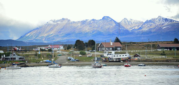 Scenic view of lake by buildings against sky