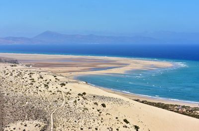 Scenic view of beach against blue sky