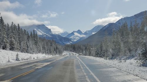 Road amidst snowcapped mountains against sky