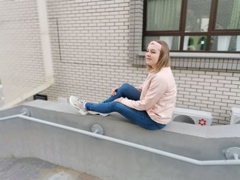 Side view of a smiling young woman sitting outdoors