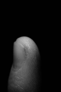 Close-up of human hand against black background