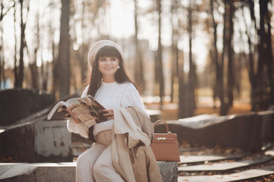 Portrait of smiling young woman sitting outdoors