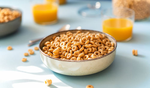 Breakfast concept with cold cereals and orange juice on blue background