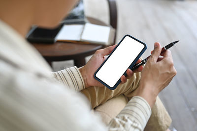 Midsection of man using mobile phone